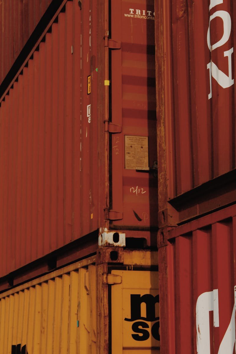 Close-up view of stacked rusty cargo containers highlighting industrial textures.